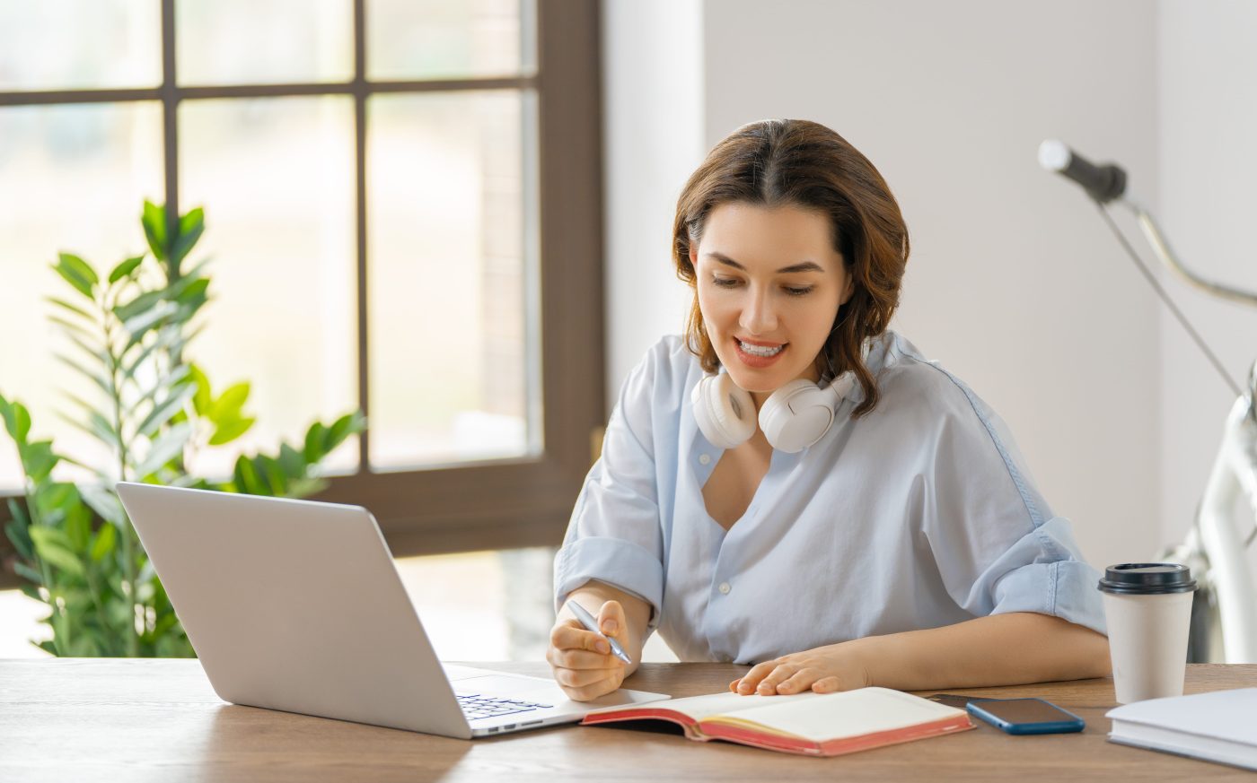 Happy young woman working, watching webinar, podcast on laptop, having remote conversation.