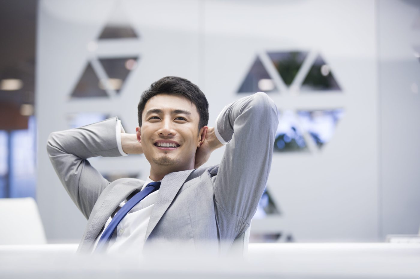 Young Chinese businessman thinking in office