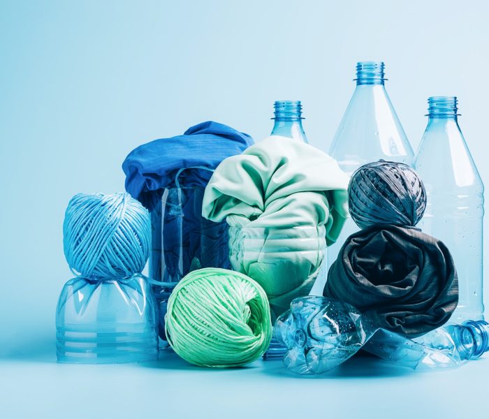 Empty plastic bottle and various fabrics made of recycled polyester fiber synthetic fabric Empty plastic bottle and various fabrics made of recycled polyester fiber synthetic fabric